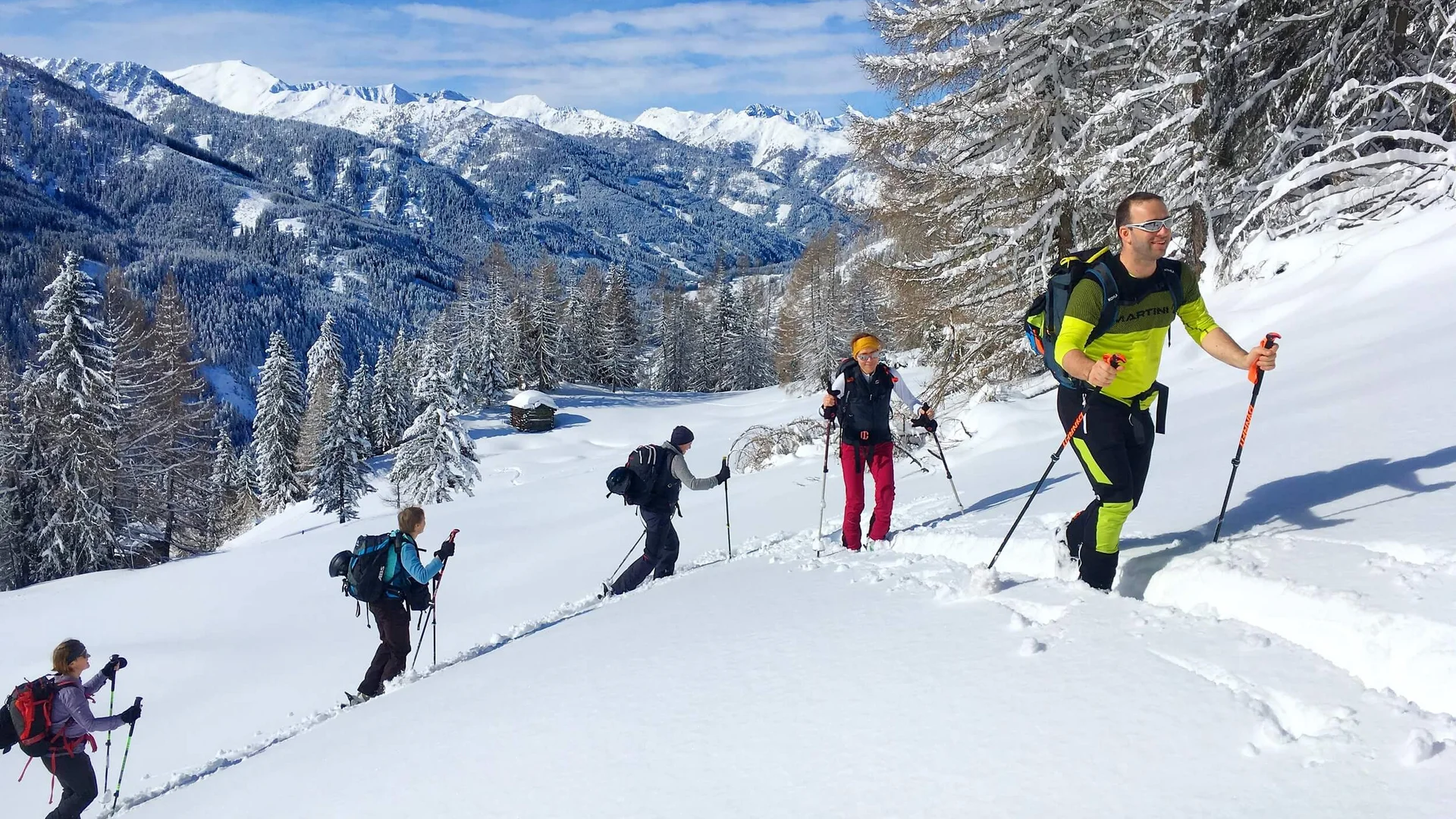 Ski touring holidays in Nassfeld-Pressegger See | Lesachtal | Weissensee © Mario Lugger Group snowshoe hiking in snowy mountain landscape under clear blue sky