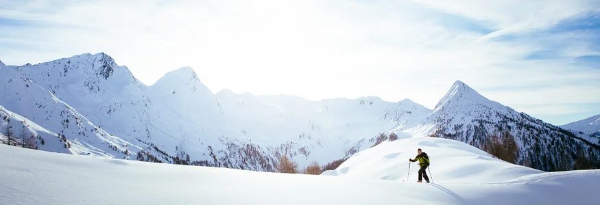 Alpiner Geheimtipp Passeiertal © Tourismusverein Passeiertal - Benjamin Pfitscher Skifahrer wandert auf schneebedecktem Berg im Sonnenlicht