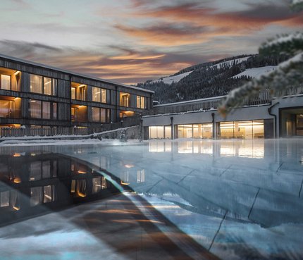 Eco-Aparthotel HIRBEN Naturlaub © Manuel Kottersteger Modern hotel with lit windows at sunset and pool in the foreground