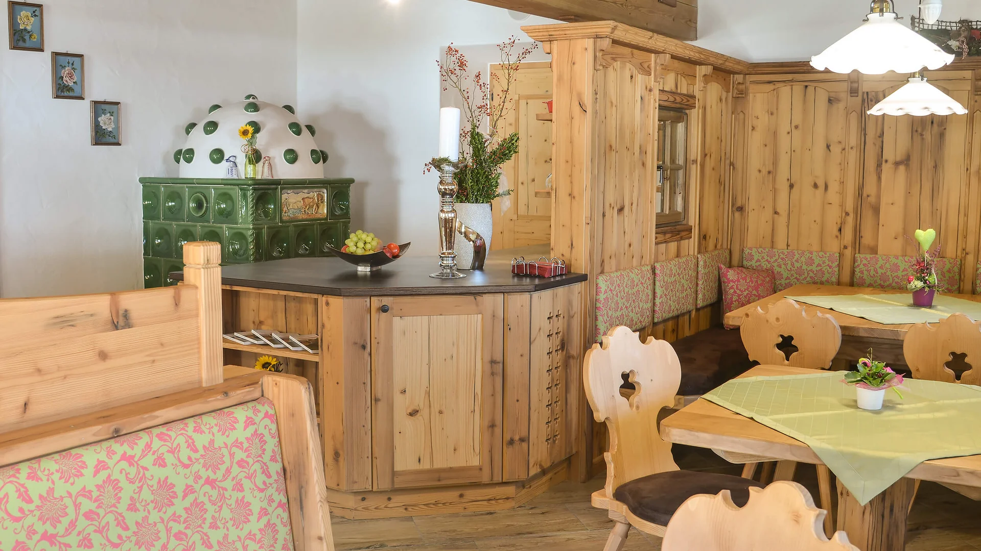 Bauernhof Krahlehen © Thomas Müller Cozy room with wooden furniture, green tile stove, and decorated tables