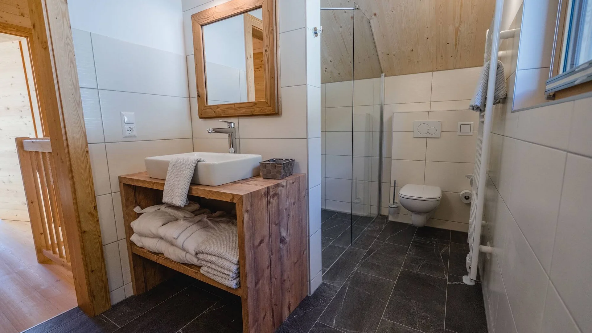 Modernes Badezimmer mit Holzwaschtisch und weißer Toilette