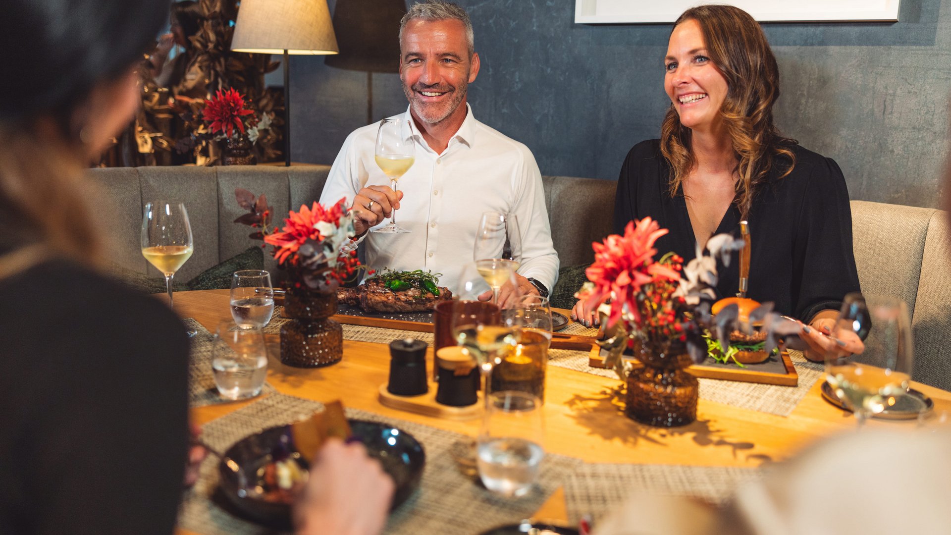 Kulinarik im Das Walchsee © Mathäus Gartner Menschen genießen ein Abendessen mit Wein und Gesprächen in einem Restaurant