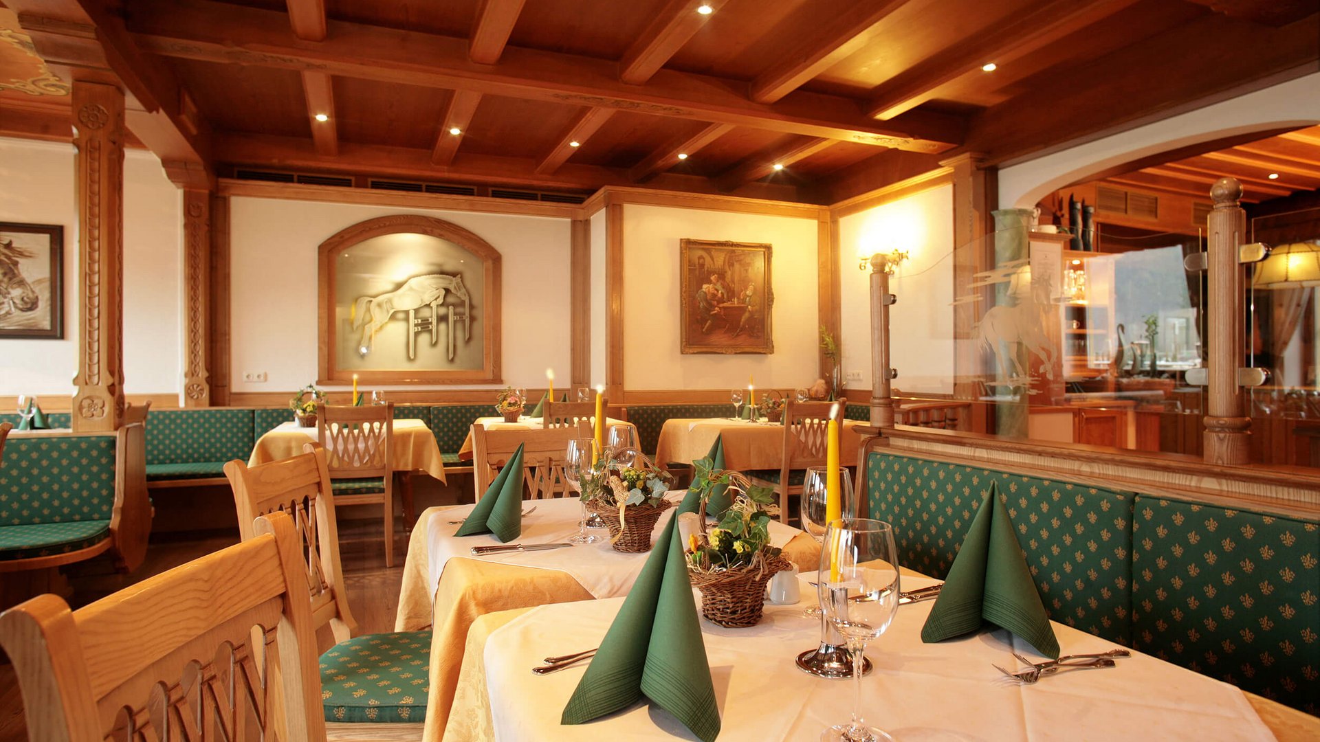Restaurant with wooden decor and tables set with green napkins