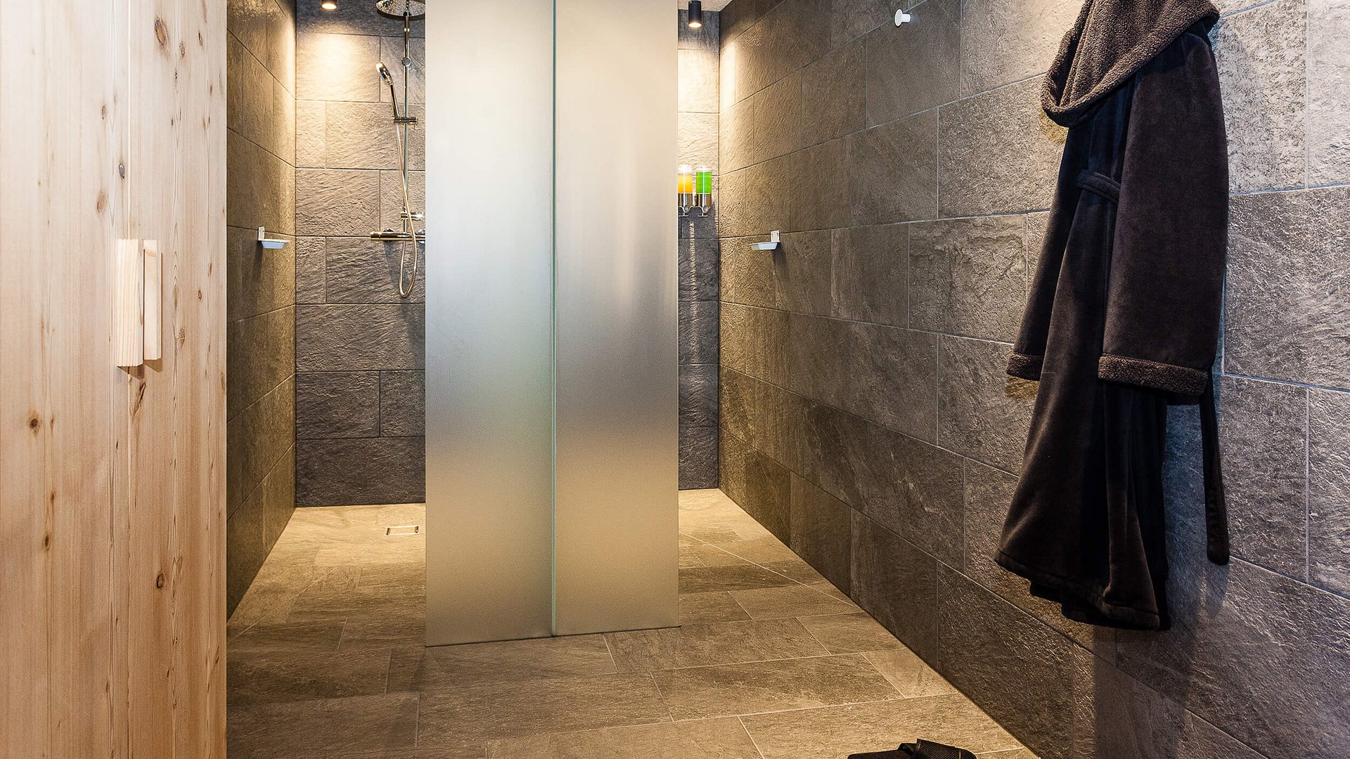 Moderne Dusche mit Holz- und Steinelementen, Bademantel und Hausschuhe