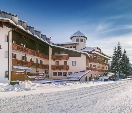 Alpenhotel Karwendel © Hotel Karwendel Bernhard Rödlach BetriebsGmbH Schneebedecktes Alpenhotel mit blauem Himmel und verschneiter Straße