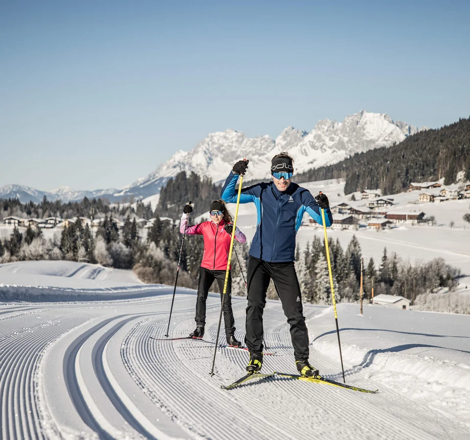 Volksbiathlon © Mirja Geh Zwei Menschen beim Langlaufen auf einer präparierten Loipe im schneebedeckten Gebirge
