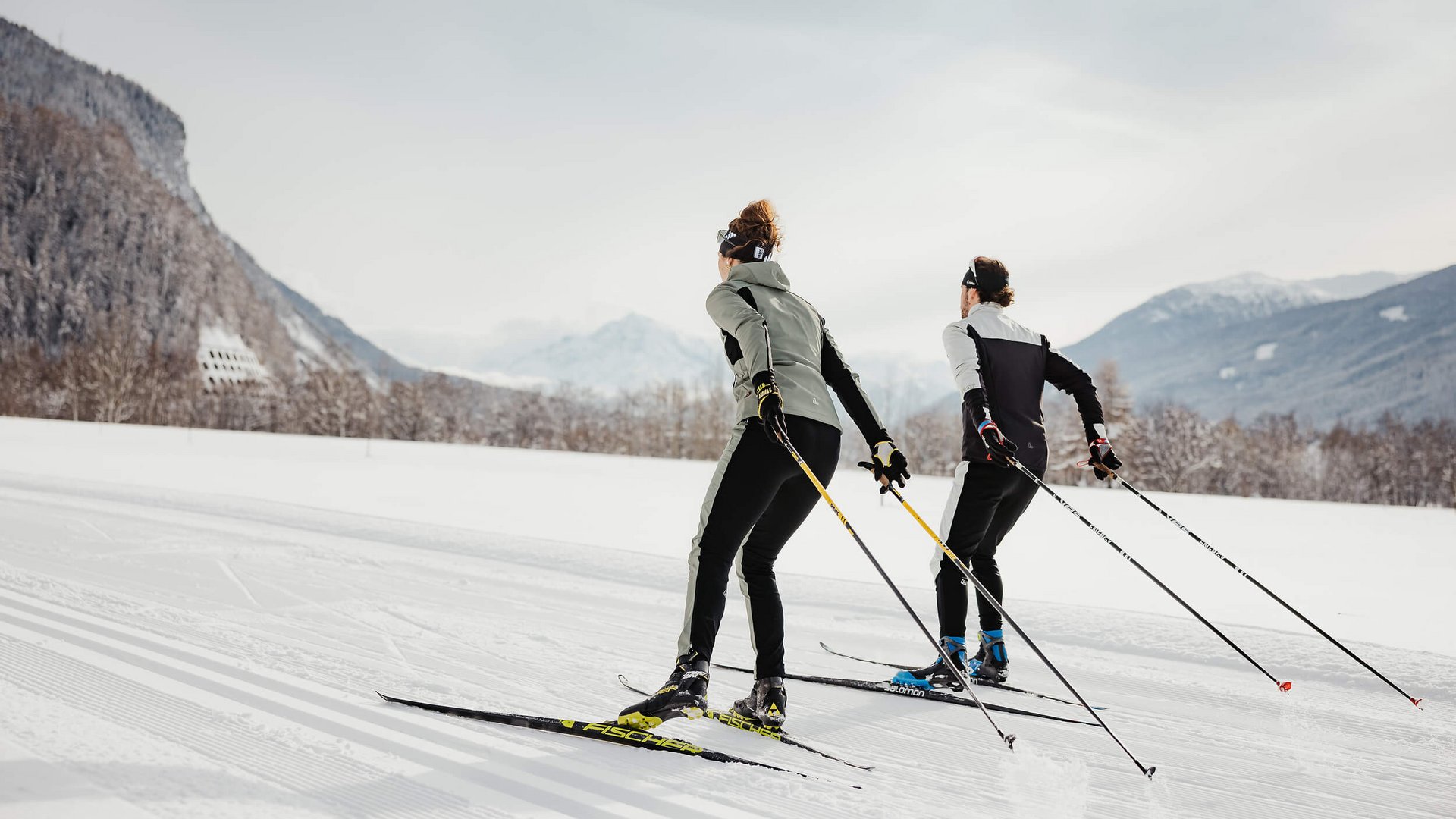 Zwei Skifahrer beim Langlaufen in verschneiter Berglandschaft