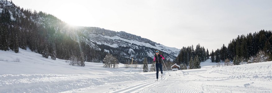 Unterwegs im Nordic Zentrum Oberstdorf © Frithjof Kjer Person beim Skilanglauf auf verschneiter Loipe vor Bergkulisse bei Sonnenschein