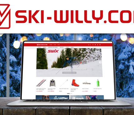 Laptop zeigt ski-willy.com Webseite mit Wintersportausrüstung vor verschneitem Fenster