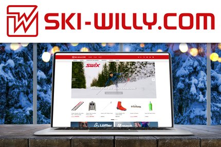 Laptop zeigt ski-willy.com Webseite mit Wintersportausrüstung vor verschneitem Fenster