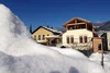 Sammelanfragen © Bierhotel Loncium Schneebedeckte Häuser unter klarem blauem Himmel in den Bergen