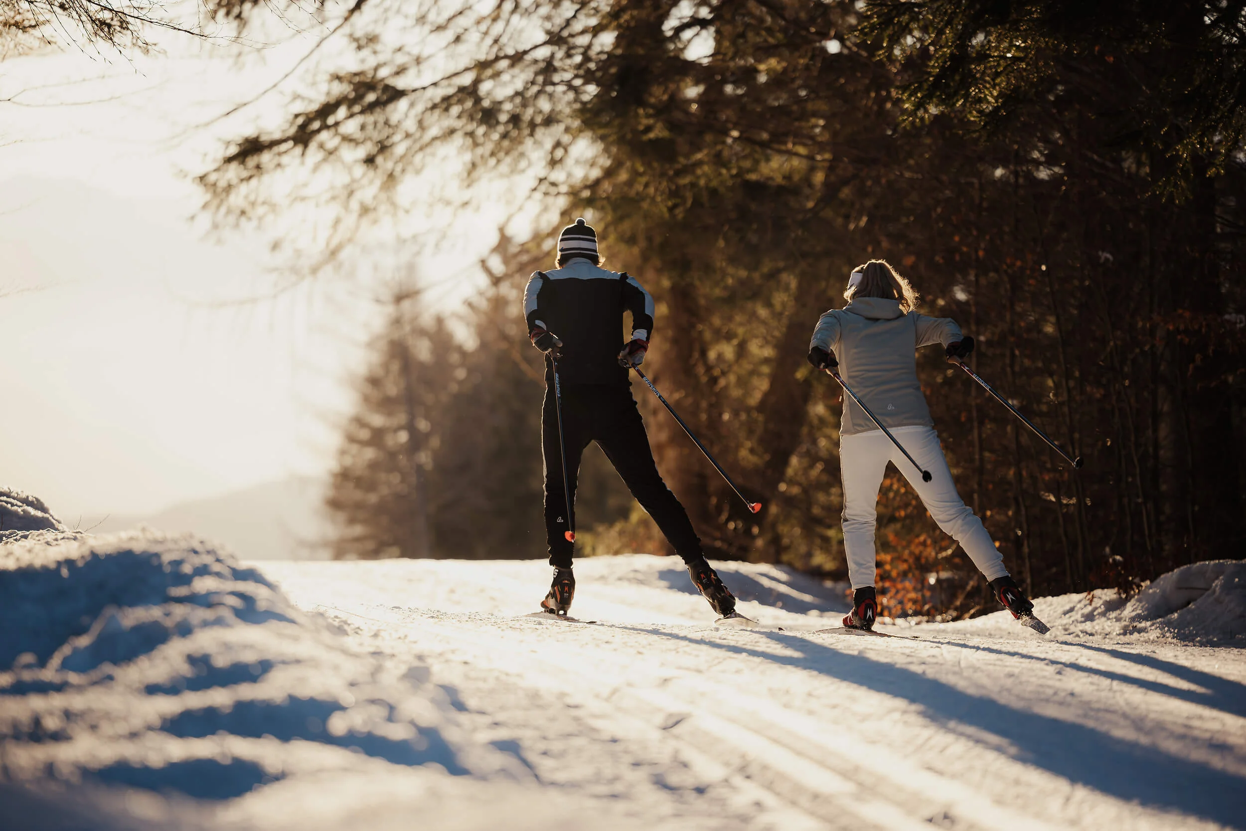 Slowenien © Alex Moling Zwei Personen beim Skilanglauf auf verschneitem Weg bei Sonnenlicht