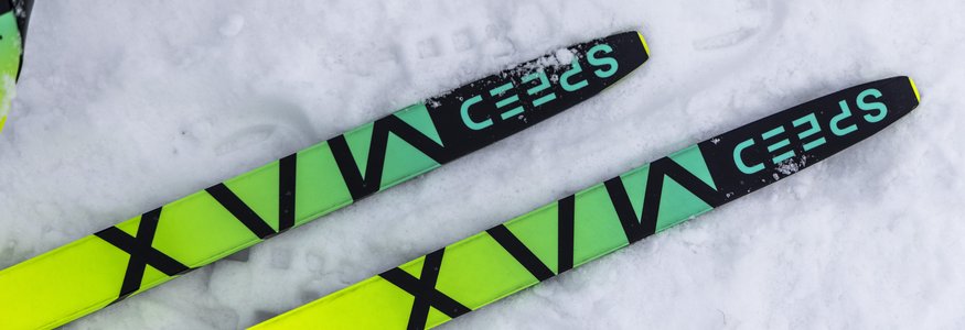 Gelbe Langlaufski auf Schnee mit der Aufschrift SPEED MAX