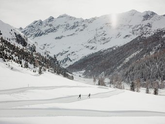 nordic³ © Alex Moling Zwei Skifahrer auf einer Spur in schneebedecktem Tal vor verschneiten Bergen
