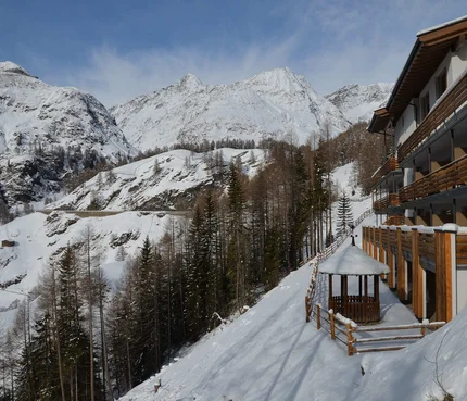 Schneebedeckte Berge und moderne Berghütte mit Holzveranda im Winter