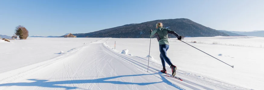 Salzburger Lungau © Salzburger Lungau Person beim Langlaufen auf präparierter Schneepiste bei klarem Himmel