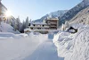 Sammelanfragen © Alfred Tschager Schneebedeckter Weg zu einem Hotel im sonnigen Wintergebirge
