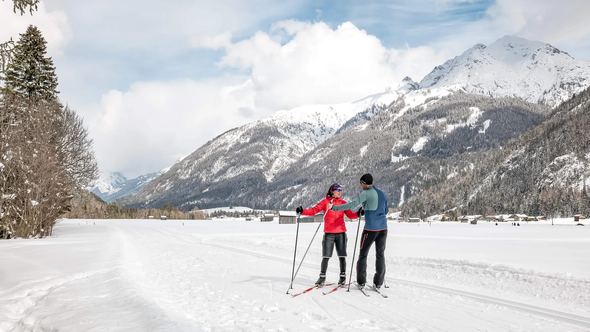 Loipen & Loipenbericht © Lechtal Tourismus / Radomir Gabric Zwei Langläufer in roter und blauer Kleidung in verschneiter Berglandschaft