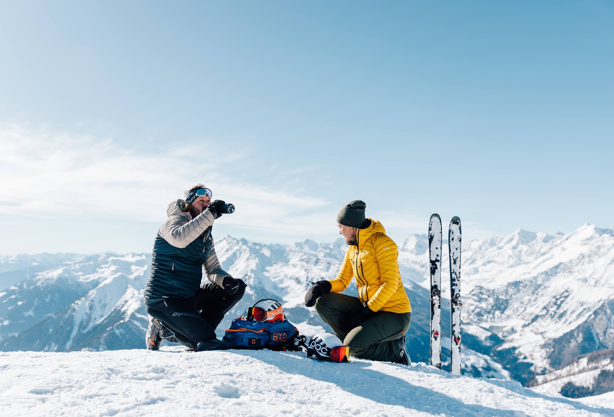 Zwei Skifahrer machen Pause im Schnee mit Bergblick
