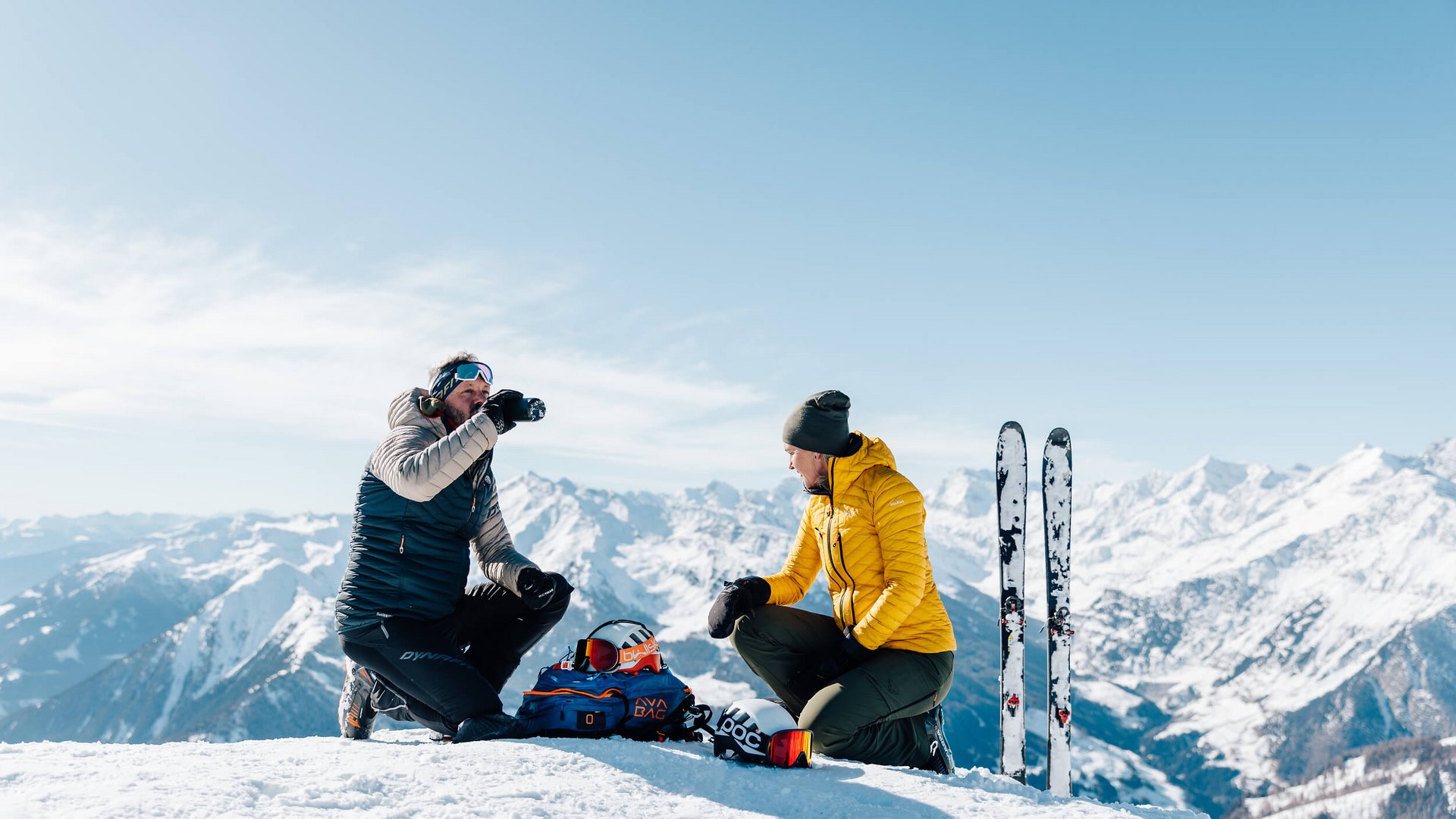 Zwei Skifahrer machen Pause im Schnee mit Bergblick