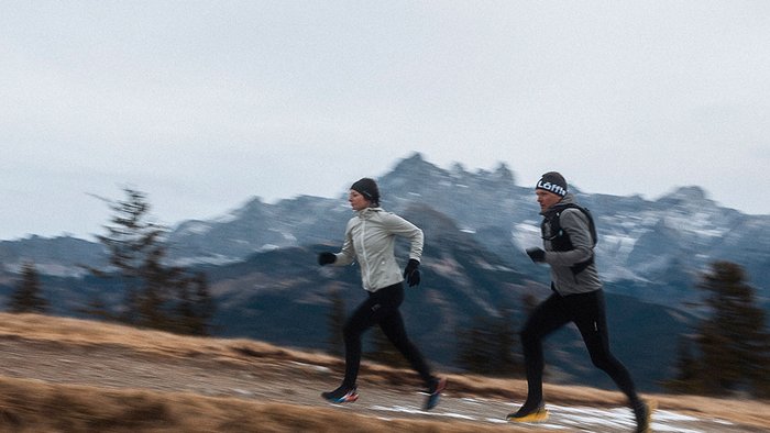 Zwei Personen joggen im Gebirge bei kaltem Wetter