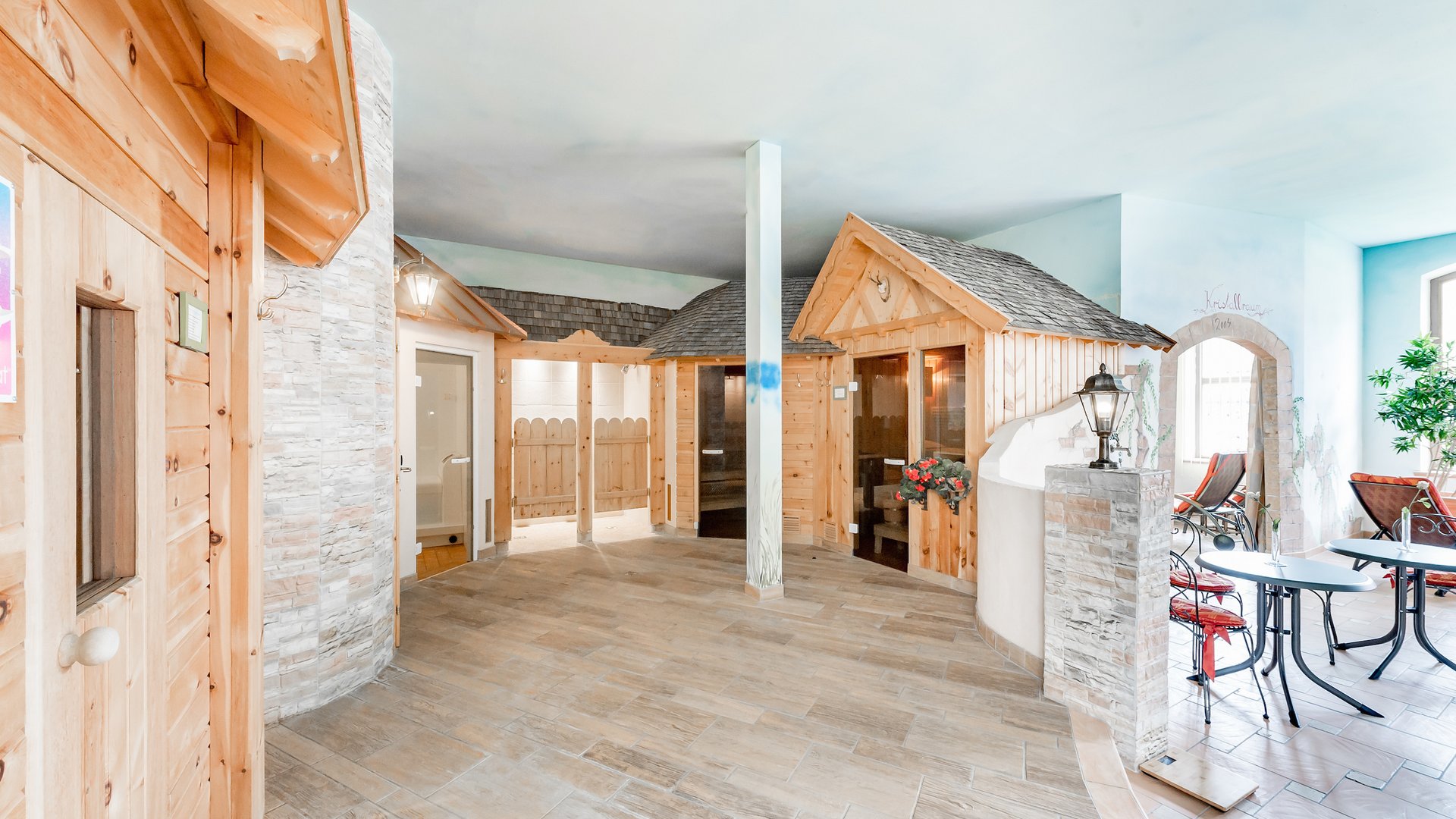 Indoor area with wooden cabins and seating in a wellness spa