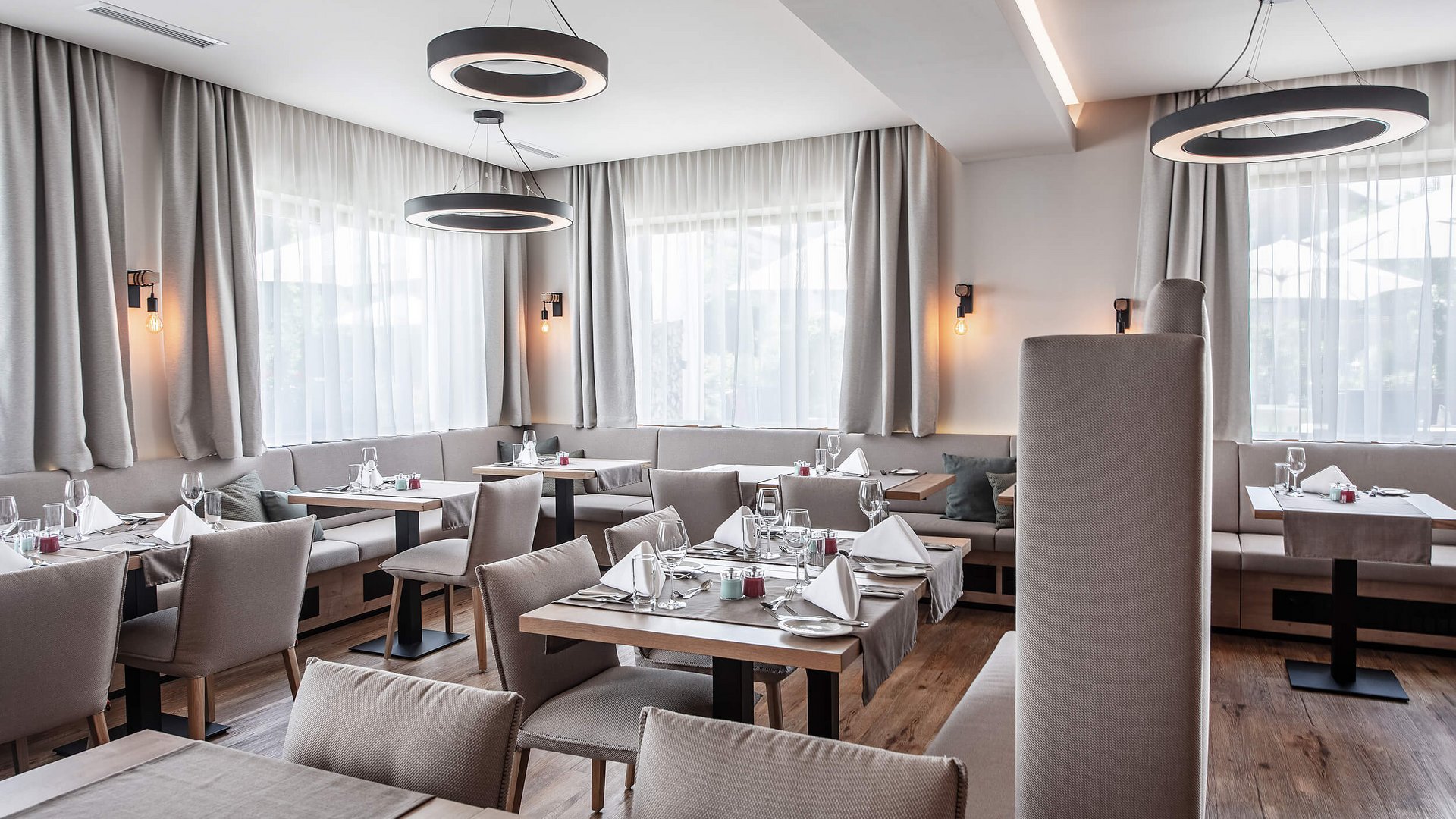 Bright modern restaurant interior with set tables and gray chairs