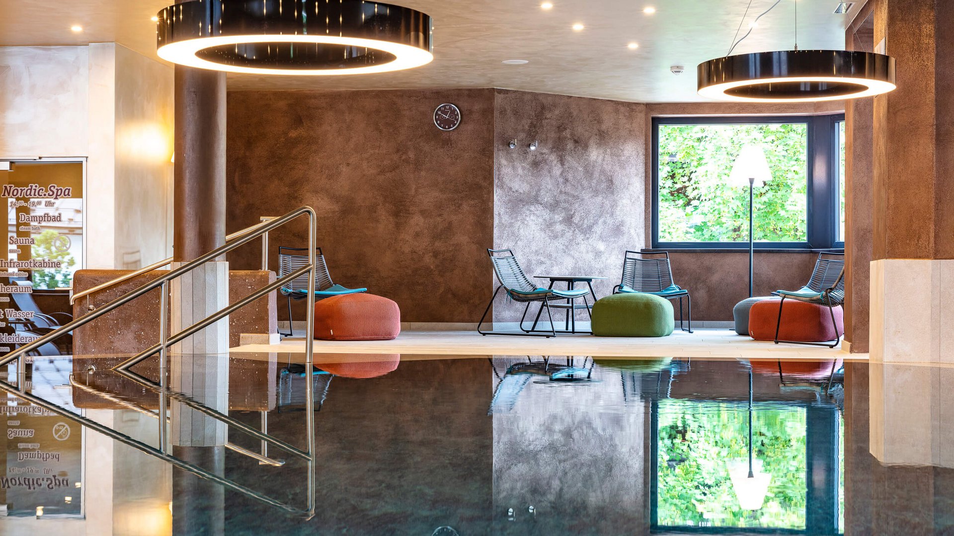 Indoor relaxation area with pool and comfortable seating arrangements