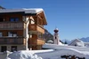 Sammelanfragen © Heinrich Moriggl Schneebedecktes Holzalmenhaus und Uhrturm in einem Alpenort