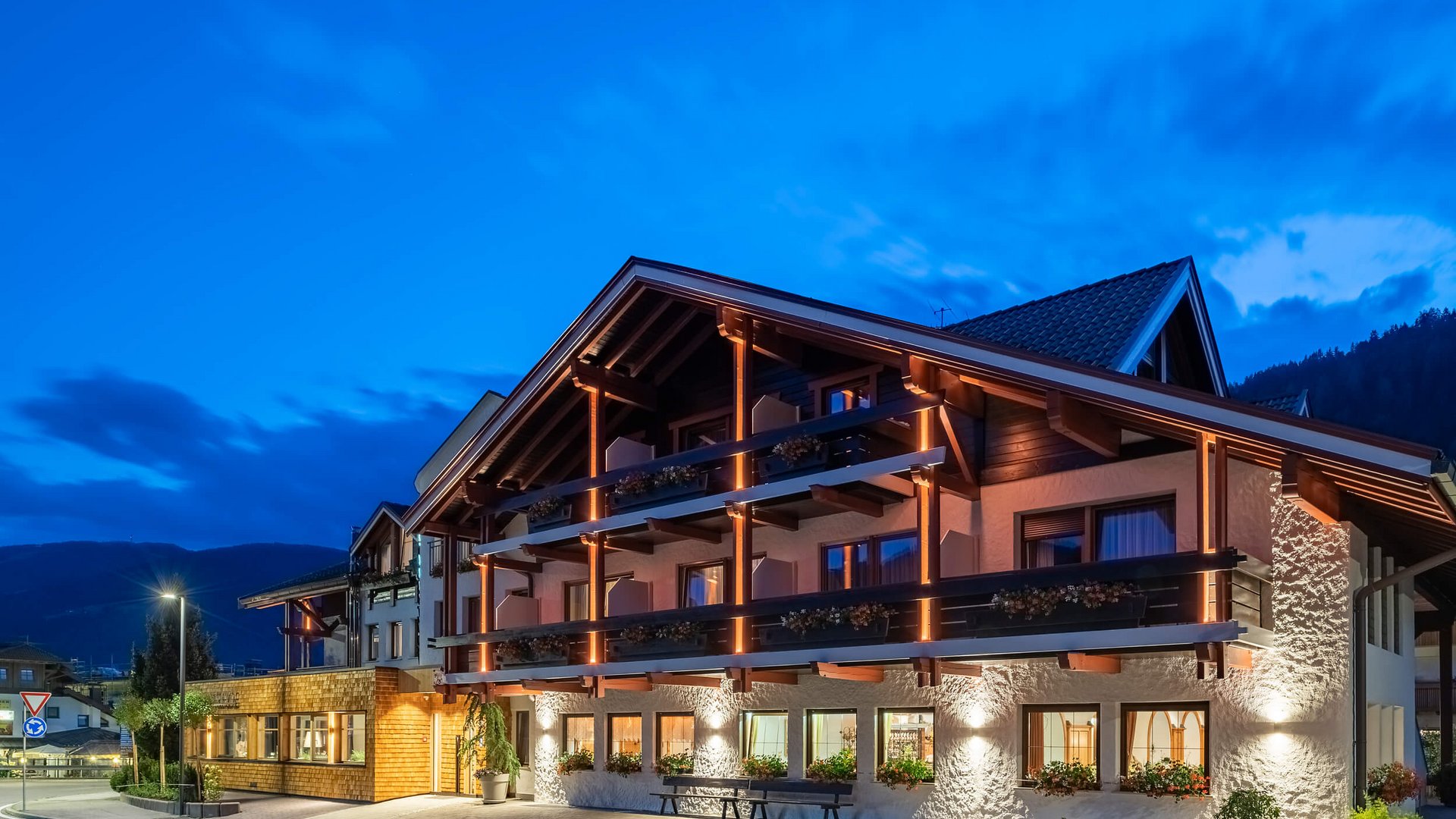 Beleuchtetes alpines Hotelgebäude in der Abenddämmerung