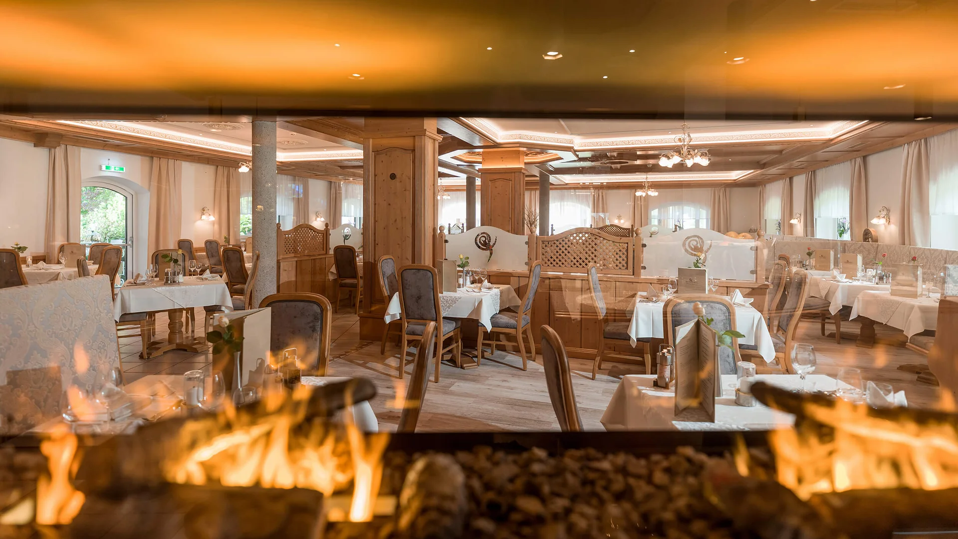 Cozy restaurant with wooden furniture and a burning fireplace in the foreground