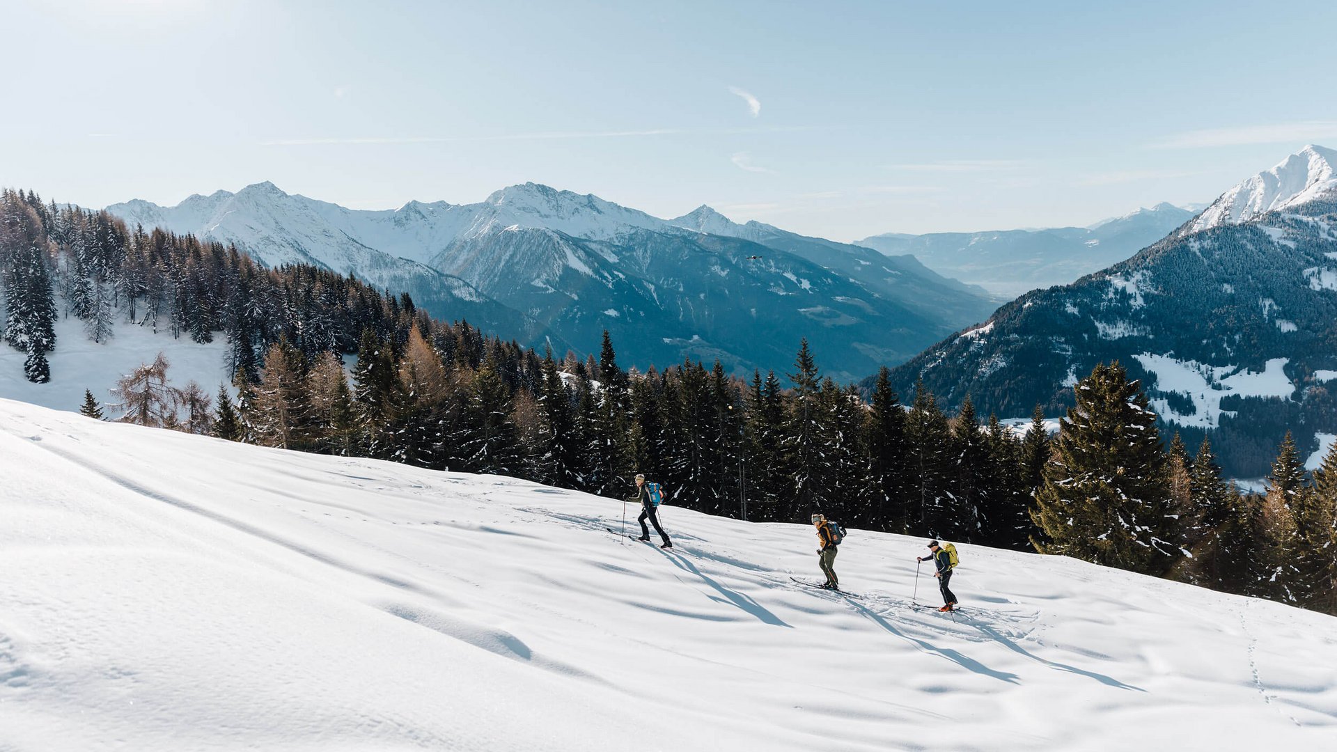 Deine Skitouren-Bucketlist für diesen Winter © Tourismusverein Passeiertal - Benjamin Pfitscher Drei Skitourengeher in verschneiter Berglandschaft bei klarem Himmel