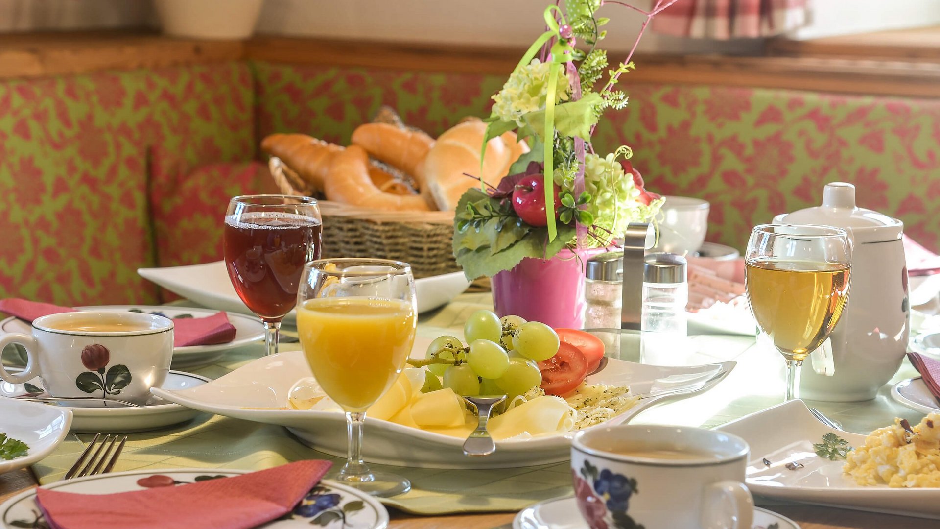 Breakfast table with juice, coffee, bread, cheese, and fruit