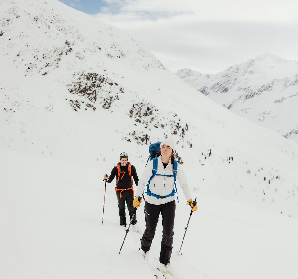 Zwei Skitourengeher wandern im verschneiten Gebirge