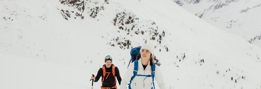 Zwei Skitourengeher wandern im verschneiten Gebirge