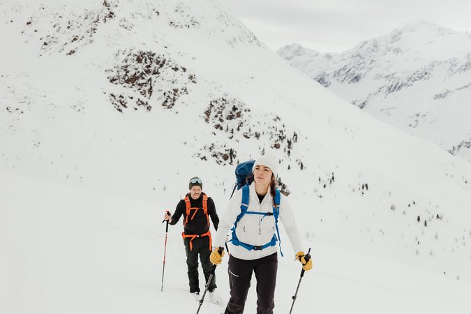 Zwei Skitourengeher wandern im verschneiten Gebirge