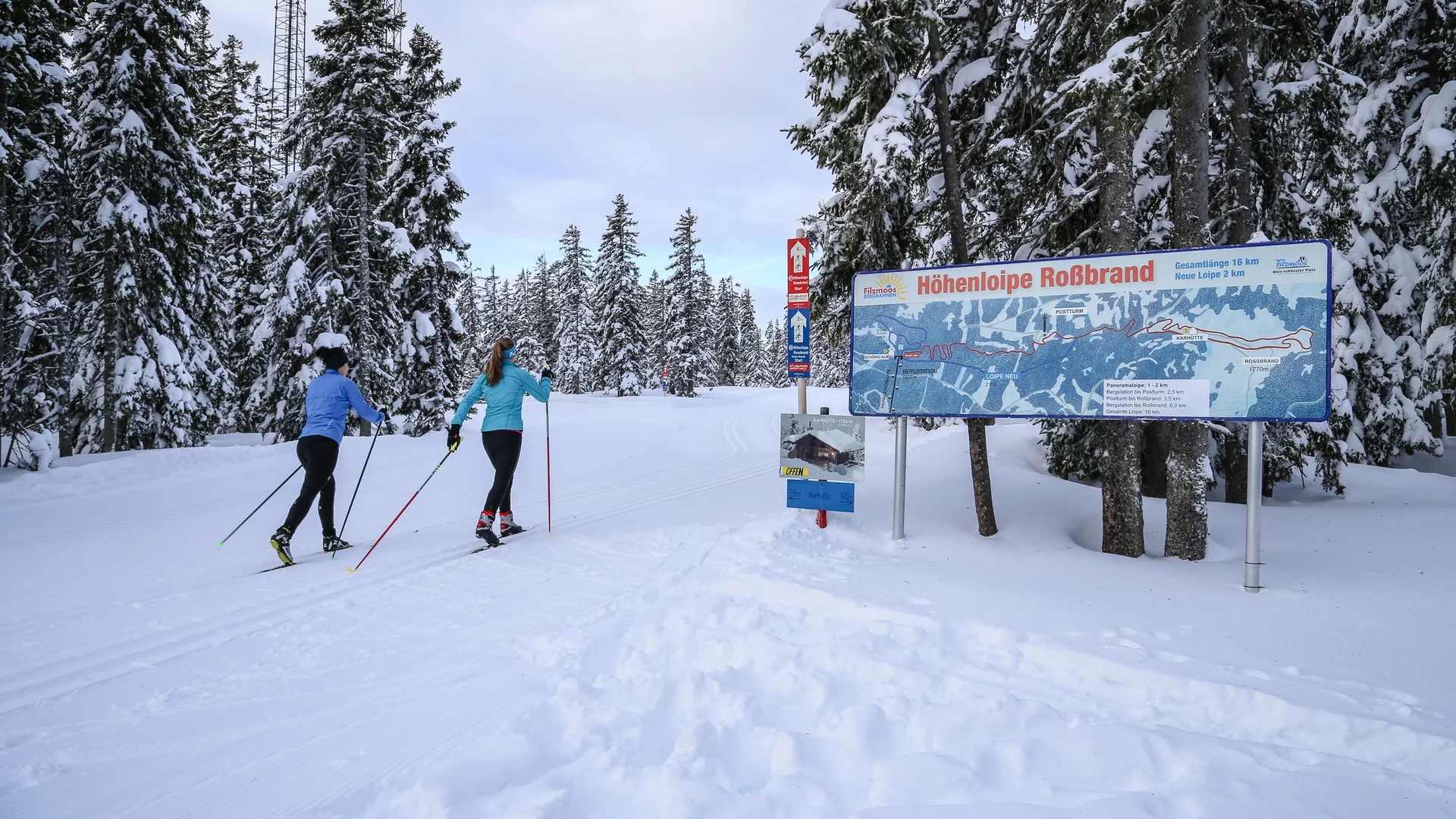 Bauernhof Krahlehen © Coen Weesjes Two people cross-country skiing beside a trail map in a snowy forest