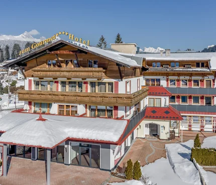 Schneebedecktes Hotelgebäude mit Bergen im Hintergrund