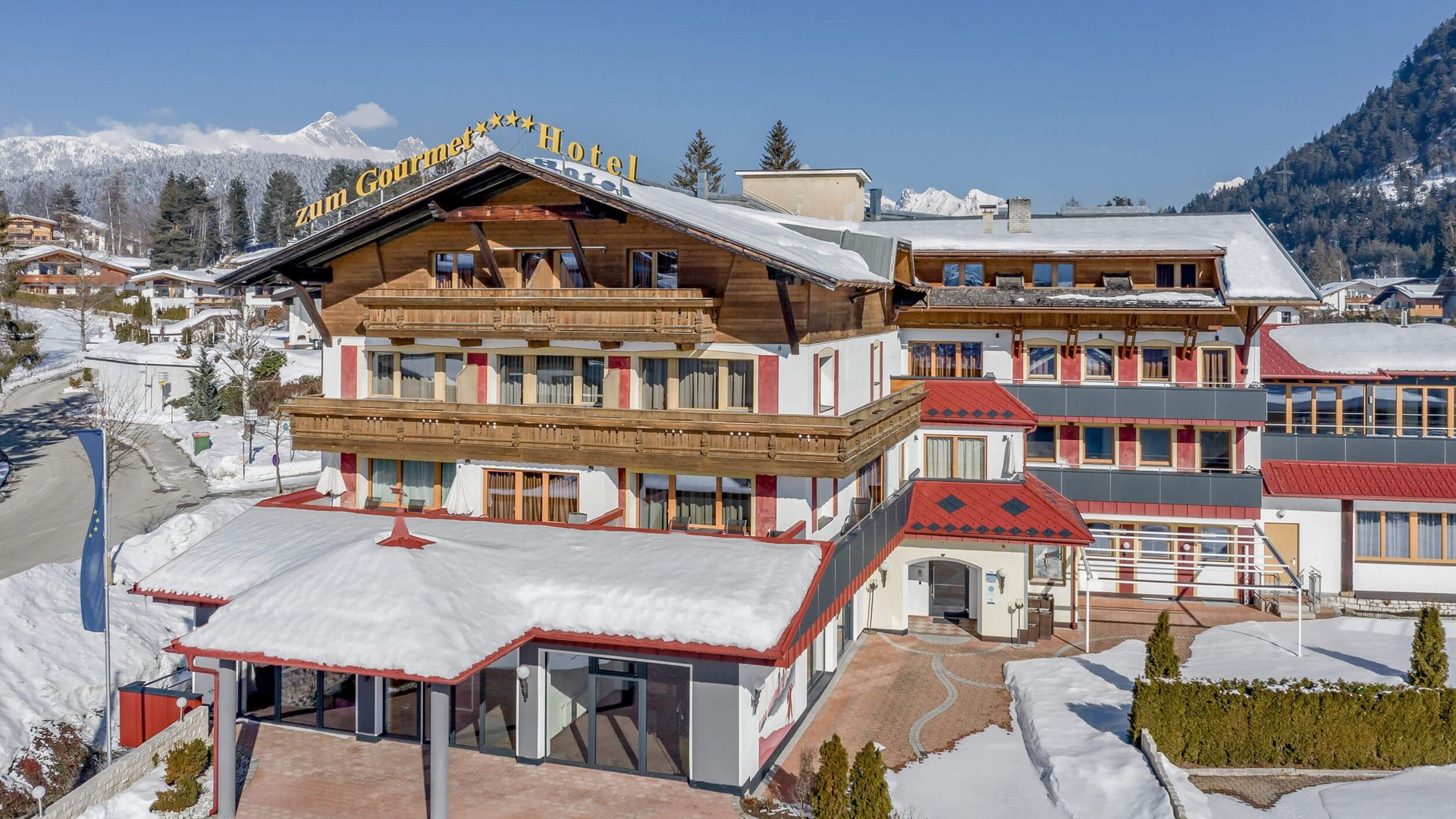 Snow-covered hotel building with mountains in the background