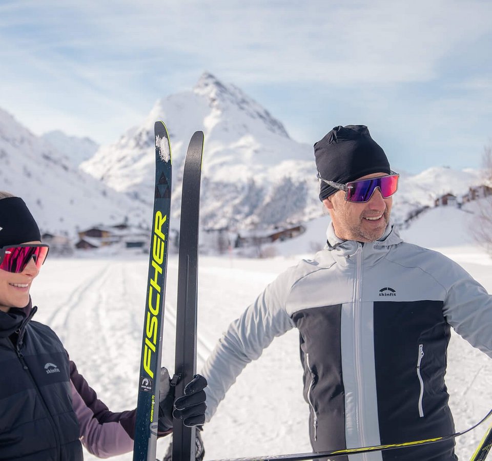 Ein Paar in Skiausrüstung im verschneiten Gebirge
