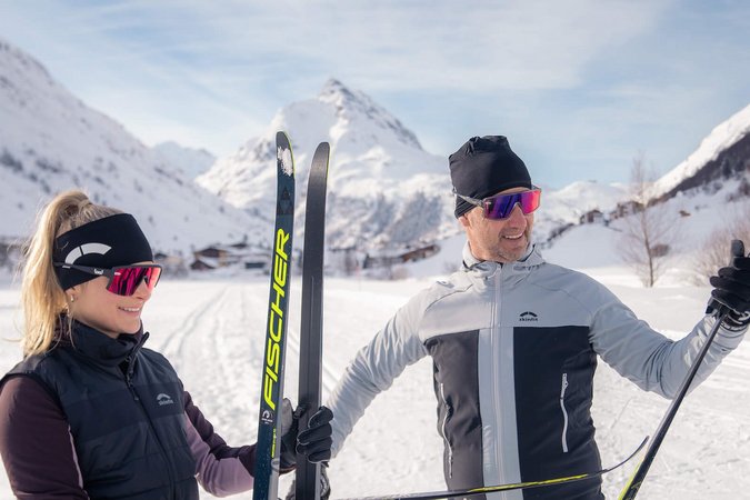 Ein Paar in Skiausrüstung im verschneiten Gebirge