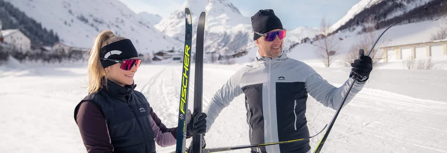 Ein Paar in Skiausrüstung im verschneiten Gebirge
