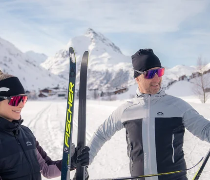 Ein Paar in Skiausrüstung im verschneiten Gebirge