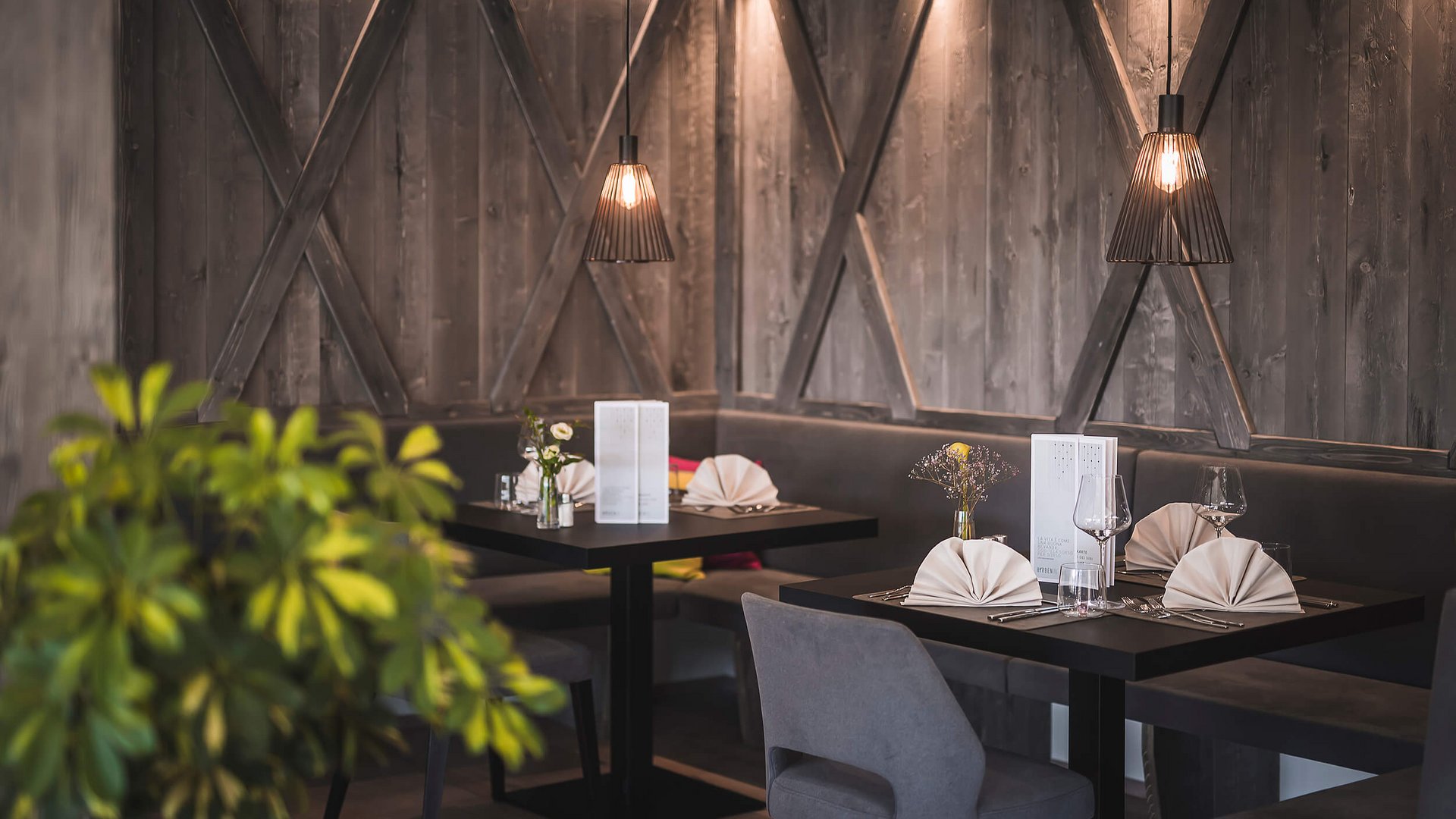 Gedeckte Tische in einem modernen Restaurant mit gedämpfter Beleuchtung