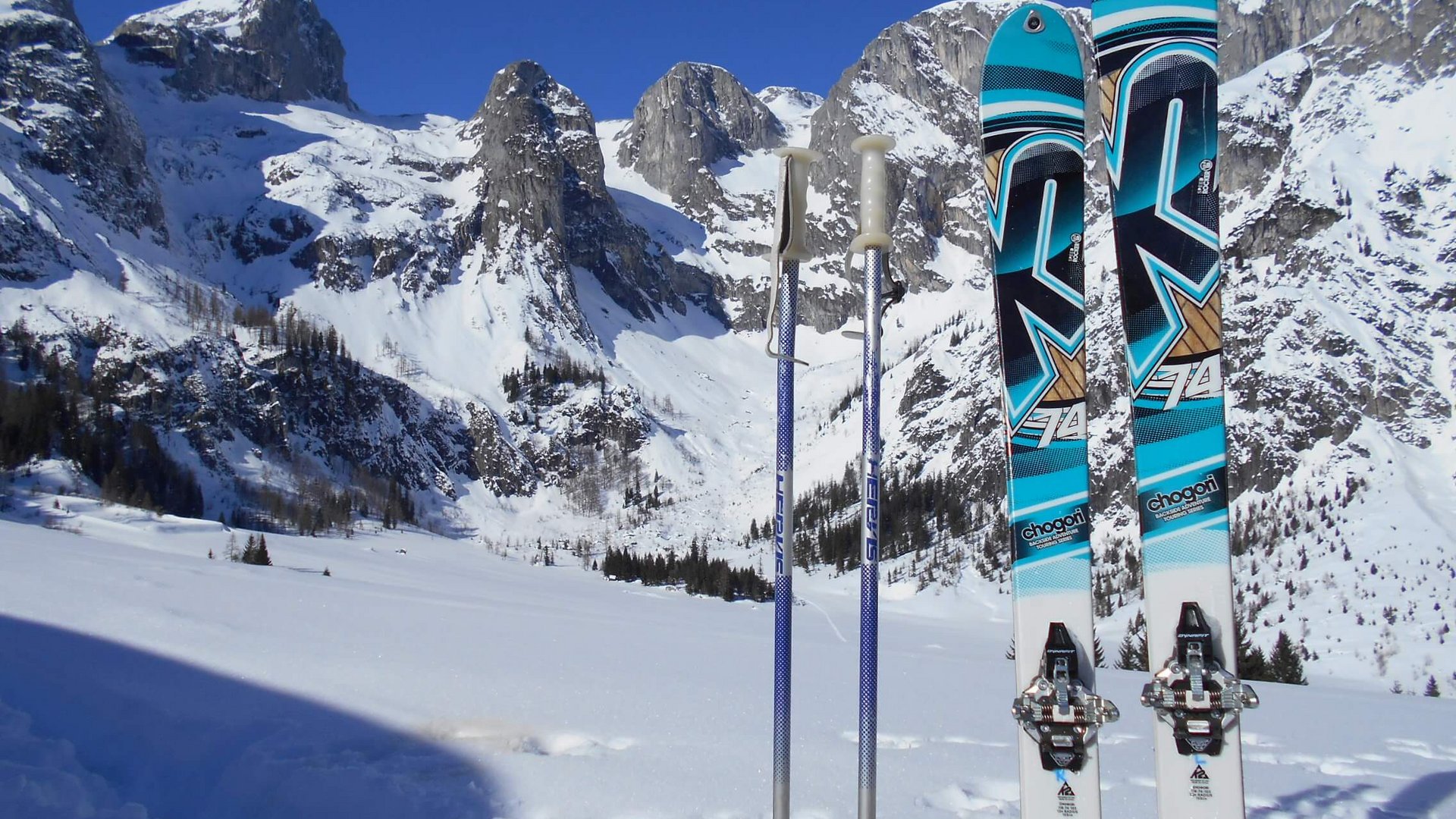 Skitouren Urlaub im Tennengau © Berghotel Lämmerhof Skier und Skistöcke vor verschneiten Bergen unter blauem Himmel