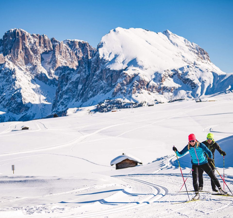 Langlauf & Kultur vereint auf der Seiser Alm © Seiser Alm Marketing - Werner Dejori Zwei Langläufer bei sonnigem Wetter vor schneebedeckten Bergen