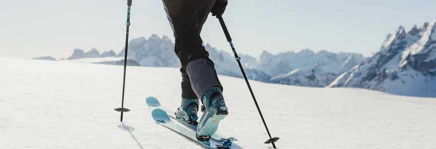 Skifahrer unterwegs auf verschneitem Berg mit Bergpanorama
