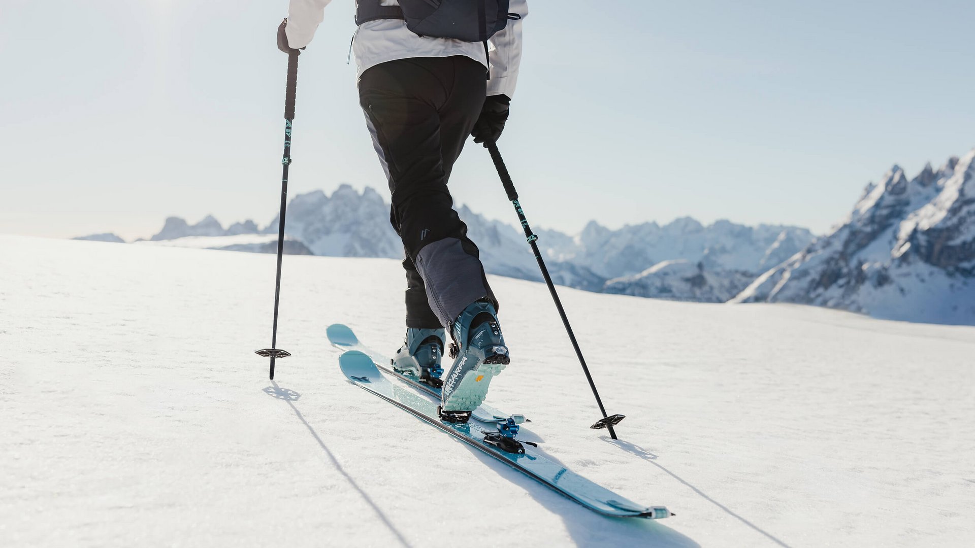 Skifahrer unterwegs auf verschneitem Berg mit Bergpanorama