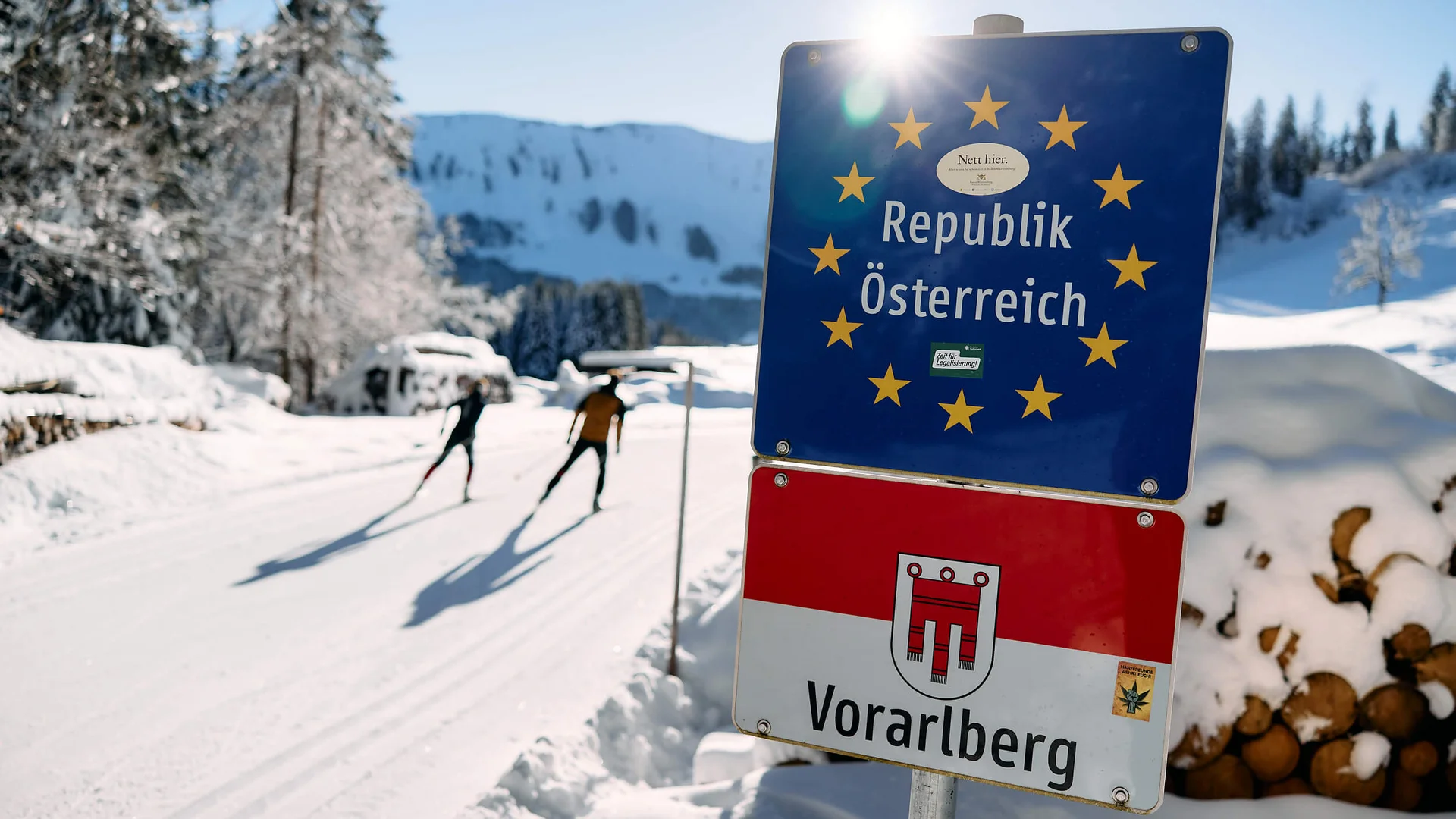 Langlauf Urlaub im Kleinwalsertal © Kleinwalsertal Tourismus - Oliver Farys Österreich- und Vorarlberg-Schilder an einer verschneiten Langlaufloipe