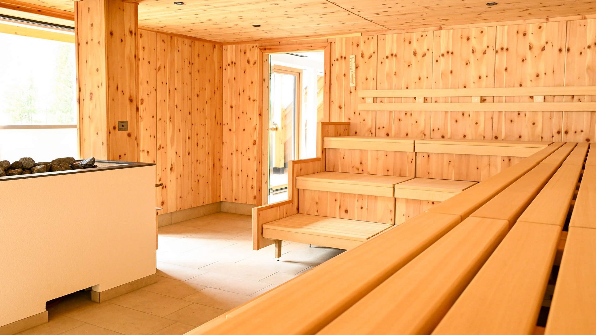 Innenansicht einer leeren Sauna mit Holzwänden und Bänken